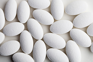 Image showing Pile of white drug pills laying on white background.