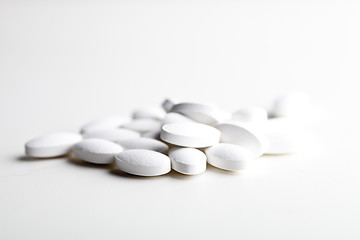 Image showing Pile of white drug pills laying on white background.