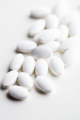 Image showing Pile of white drug pills laying on white background.