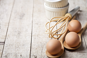 Image showing Fresh chicken eggs and kitchen utensil on rustic wooden table ba