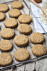 Image showing Baking grid with fresh oat cookies on rustic wooden table backgr