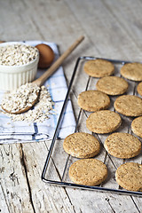 Image showing Baking grid with fresh oat cookies on rustic wooden table backgr