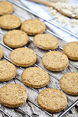 Image showing Baking grid with fresh oat cookies on rustic wooden table backgr