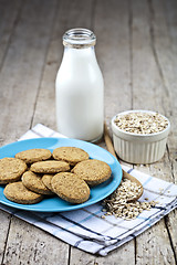 Image showing Fresh baked oat cookies on blue ceramic plate on linen napkin, b