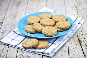 Image showing Fresh baked oat cookies on blue ceramic plate on linen napkin on