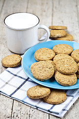 Image showing Fresh baked oat cookies on blue ceramic plate on linen napkin an