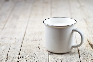 Image showing Fresh milk on white ceramic cup on rustic wooden table backgroun