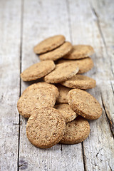 Image showing Fresh baked oat cookies on rustic wooden table.