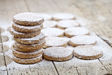 Image showing Fresh baked oat cookies with sugar powder on rustic wooden table