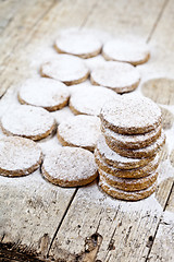 Image showing Fresh baked oat cookies with sugar powder on rustic wooden table