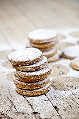 Image showing Fresh oat cookies with sugar powder on rustic wooden table.