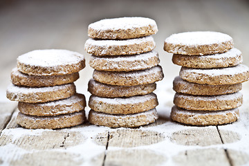 Image showing Fresh oat cookies with sugar powder on rustic wooden table.