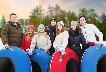 Image showing happy friends with snow tubes outdoors in winter