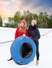 Image showing happy teenage girls with snow tubes in winter