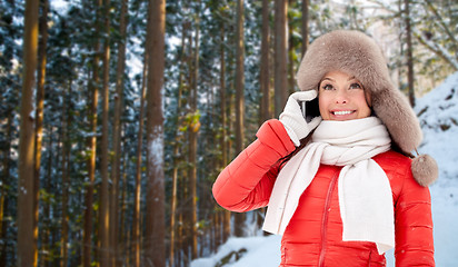 Image showing woman calling on smartphone over winter forest