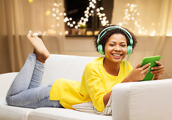 Image showing woman with tablet pc and earphones on christmas
