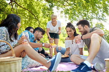 Image showing friends with drinks and food at picnic in park