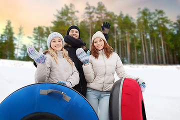 Image showing happy friends with snow tubes outdoors in winter