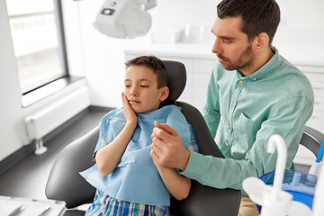 Image showing father supporting son at dental clinic