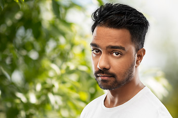 Image showing sad young indian man over green natural background