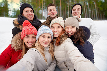 Image showing group of friends taking selfie outdoors in winter