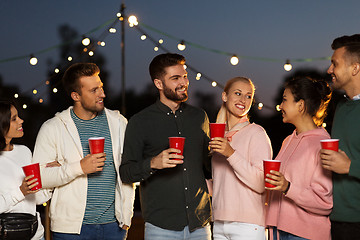 Image showing friends with party cups on rooftop at night