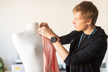 Image showing fashion designer with dummy making dress at studio