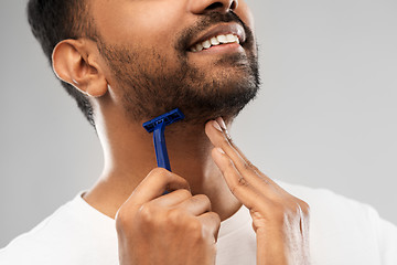 Image showing close up of man shaving beard with razor blade