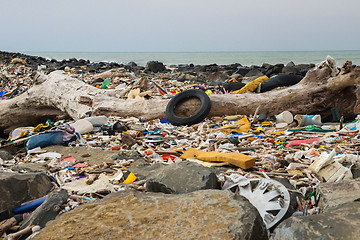 Image showing Spilled garbage on the beach near the big city. Empty used dirty plastic bottles and other garbage. Environmental pollution. Ecological problem.