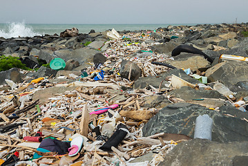 Image showing Spilled garbage on the beach near the big city. Empty used dirty plastic bottles and other garbage. Environmental pollution. Ecological problem.