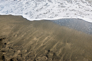 Image showing Beautiful soft wave on black sand at the sea