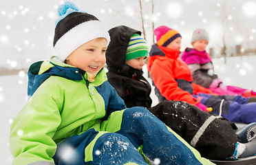 Image showing happy little kids riding sleds in winter