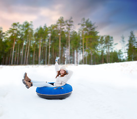 Image showing happy teenage girl sliding down hill on snow tube