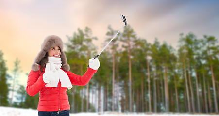 Image showing happy woman taking selfie over winter forest