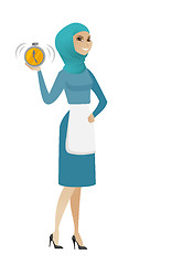 Image showing Young muslim cleaner holding alarm clock.