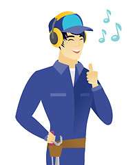 Image showing Asian mechanic listening to music in headphones.
