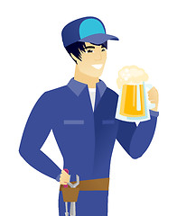 Image showing Young asian mechanic drinking beer.