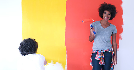 Image showing multiethnic couple painting interior wall