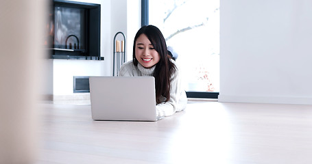 Image showing Asian woman using laptop on floor