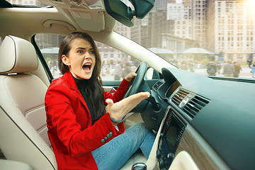 Image showing Driving around city. Young attractive woman driving a car