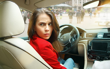 Image showing Driving around city. Young attractive woman driving a car