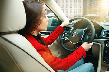 Image showing Driving around city. Young attractive woman driving a car