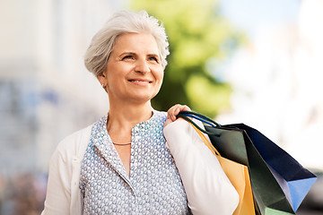 Image showing senior woman with shopping bags in city