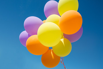 Image showing close up of colorful helium balloons in blue sky