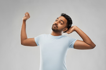 Image showing indian man stretching over grey background