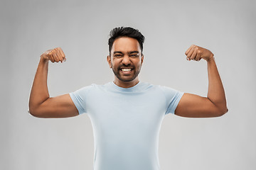 Image showing indian man showing biceps over grey background