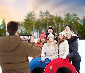 Image showing friends with snow tubes taking photo by tablet pc