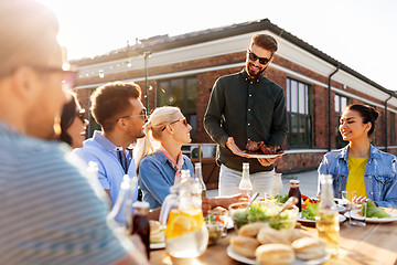 Image showing friends at barbecue party on rooftop in summer