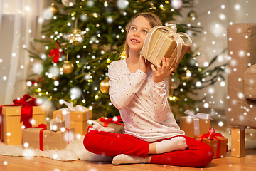 Image showing smiling girl with christmas gift at home