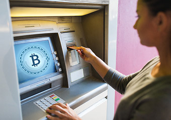 Image showing close up of woman inserting card to atm machine